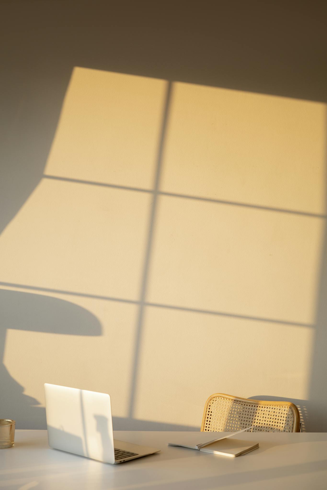 Chair and Table in a Room with Shadow of Window on Wall