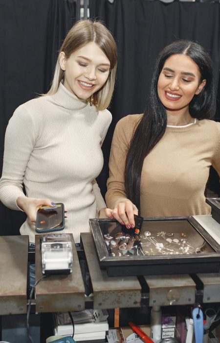 Girlfriends paying with smartphone for purchases